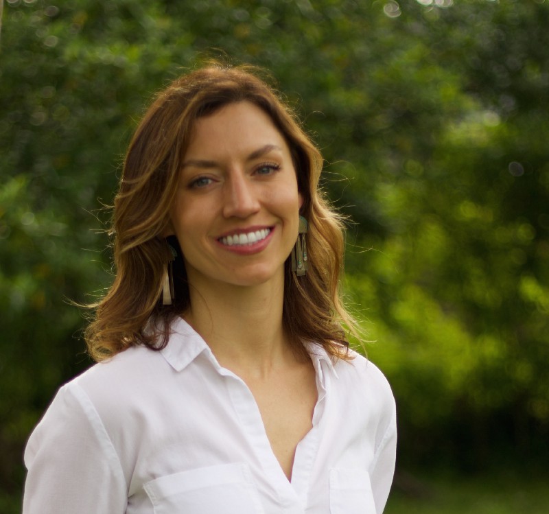 Layne Roland, LCSW, in a white shirt on a background of trees